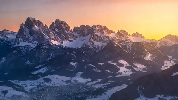 Панорамный вид на зимнюю долину Кортина-д&rsquo;Ампеццо и окружающие её горные вершины в лучах заката.