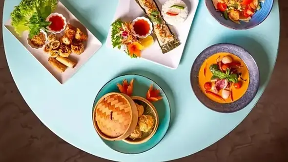 Разнообразие блюд высокой тайской кухни на столе в ресторане Pom Thai Куршевель.