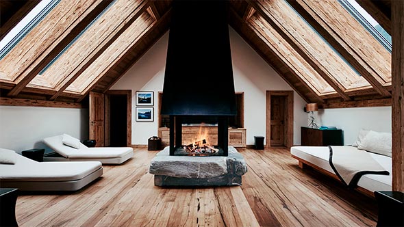 Зона релаксации в Six Senses Spa отеля The Alpina Gstaad с центральным камином на каменном постаменте