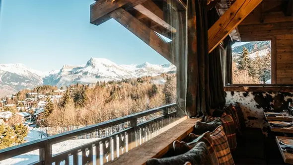 Уютный интерьер горного ресторана с панорамным видом на Альпы.