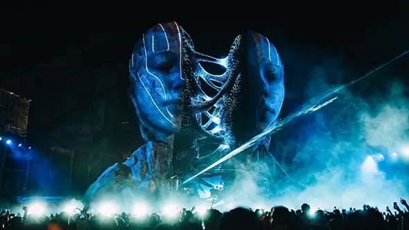 Главная сцена фестиваля Томорроуленд Винтер в Альп д Юэз с декорациями в виде огромных лиц.