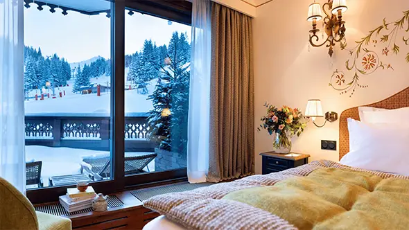 Вид на заснеженные склоны из окна номера отеля.