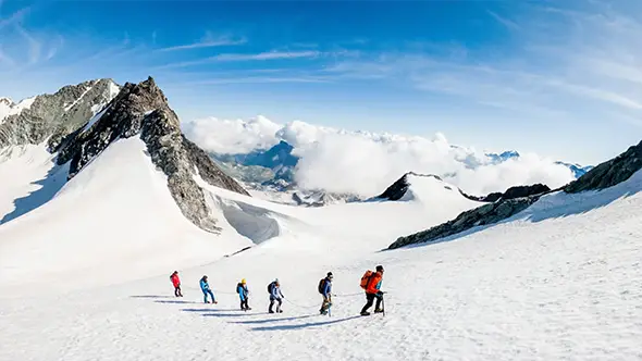 Alpinists walking roped on a glacier.