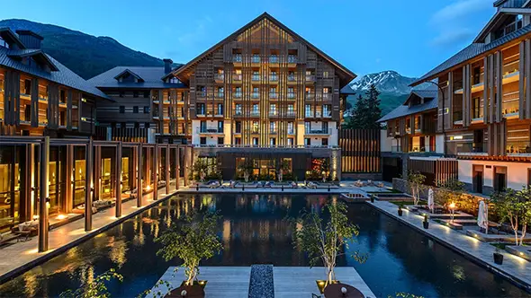 Luxury facade and outdoor pool of The Chedi Andermatt hotel.