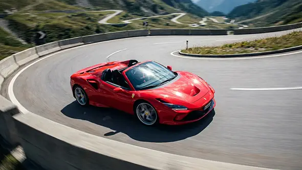 Красный Ferrari F8 Spider на горном перевале в Альпах.