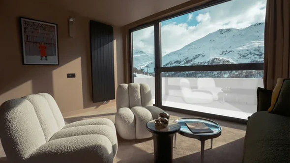 Boucle armchairs beside a picture window facing the mountain at Fahrenheit Seven Les Menuires