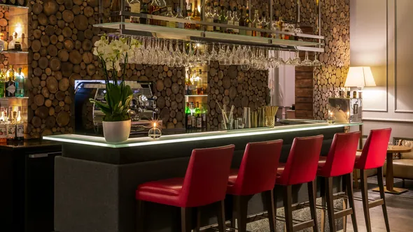Лаунж-бар с красными барными стульями и стеной из спилов дерева, Hôtel Mont-Blanc в Шамони