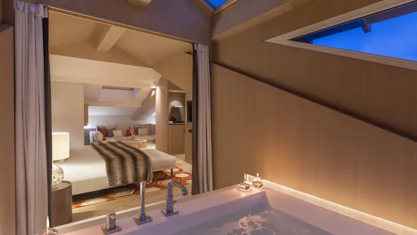 Ванна в сюите Penthouse под крышей, за ней спальня, Hôtel Mont-Blanc в Шамони