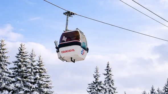 Courchevel gondola cabin above snow-covered fir trees