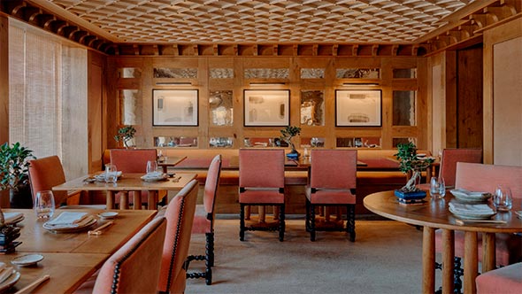 Интерьер японского ресторана Nama в отеле Aman Le M&eacute;l&eacute;zin с дубовыми панелями и эстетикой минимализма. / The interior of Nama Japanese restaurant at Aman Le M&eacute;l&eacute;zin featuring oak paneling and minimalist aesthetics.
