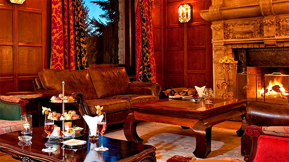 Уютный интерьер ресторана Da Vittorio St. Moritz с богато сервированным столом, свечами и стеной, украшенной большим рельефным панно с фигурами. / Cozy interior of Da Vittorio St. Moritz restaurant with a richly set table, candles, and a wall decorated with a large relief panel featuring figures.