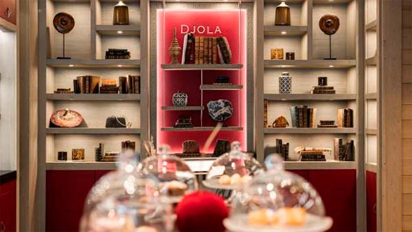 Уютный интерьер отеля Le K2 Djola с библиотекой и зоной для послеобеденного чаепития Tea Time. / Cozy interior of Le K2 Djola hotel featuring a library and a dedicated area for afternoon Tea Time.