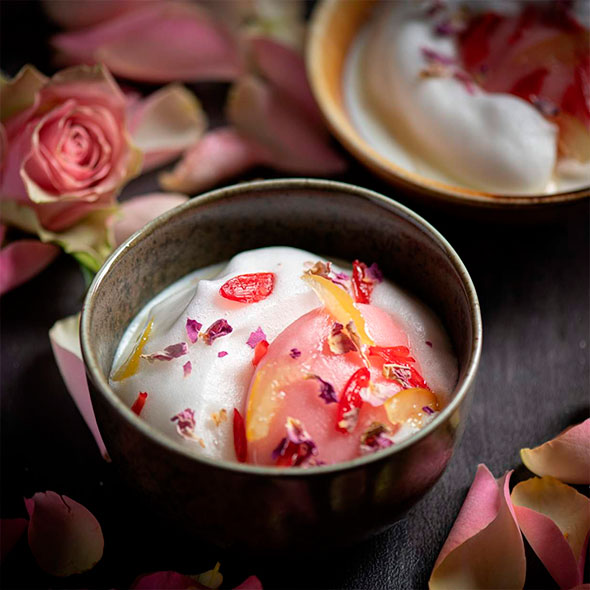 Изысканное блюдо из трюфелей и крема, поданное в темной миске на основании из артишоков, с цельными трюфелями рядом.