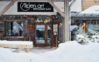 Snow-covered entrance to Alpen Art alpine restaurant in Val Thorens during snowfall