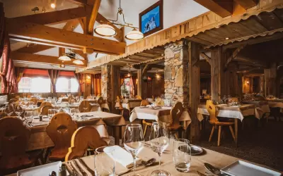 Traditional wooden interior of Le Sherpa hotel restaurant with set tables