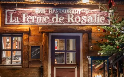 Entrance to the wooden building of La Ferme de Rosalie restaurant with a sign