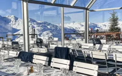 Bright dining room of La Fruitiere restaurant with panoramic windows and mountain views