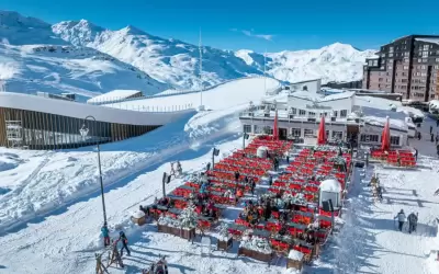 Sunny terrace of La Maison restaurant in Val Thorens among snowy mountains