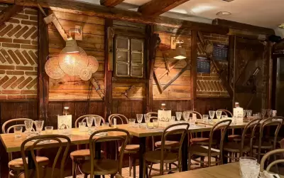 Cosy wooden interior of La Petite Ferme restaurant with set tables