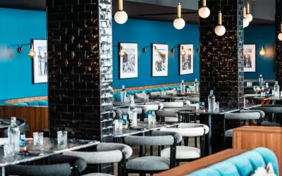 Stylish interior of La Rotisserie restaurant with blue walls and black pillars