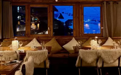 Cosy wooden interior of Le Chaudron Magique restaurant with a mountain view