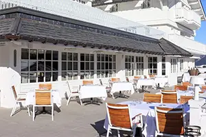 Outdoor terrace of Le Sidonie restaurant in Courchevel on a sunny day