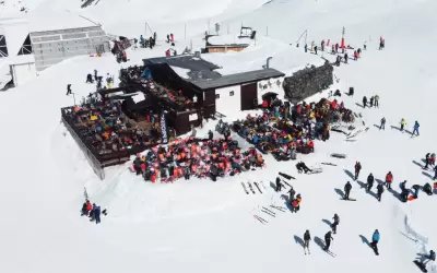 Aerial view of Les Aiguilles de Peclet restaurant and skiers on the slope