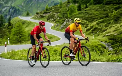 Two cyclists riding on a mountain road in Val Thorens