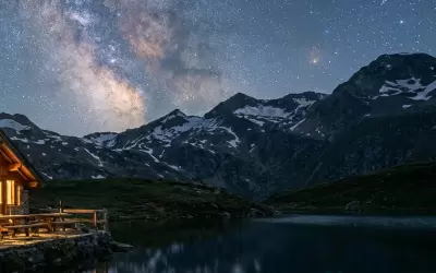 Mountain refuge by a lake under the starry sky and Milky Way