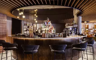 Stylish round bar at Altapura hotel with lighting and high chairs.