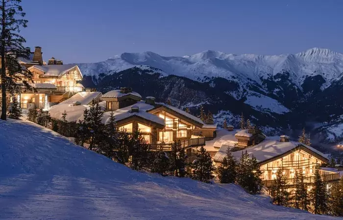 The hotel exterior lit at dusk at Le K2 Palace, Courchevel 1850