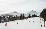 Skiers on the Bellecote piste passing Aman Le Melezin, Courchevel 1850