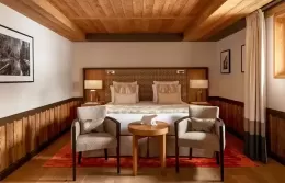 Superior room at Fouquets Courchevel with a bed and winter forest view.