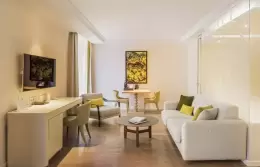 White sofa, desk and round table in a Junior Suite with Balcony, Hotel Mont-Blanc Chamonix