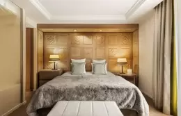 Double bed with fur throw and bedside lamps in a Prestige Room, Hotel Mont-Blanc Chamonix