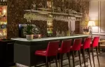 Lounge bar with red bar stools and a log-stack wall, Hotel Mont-Blanc Chamonix