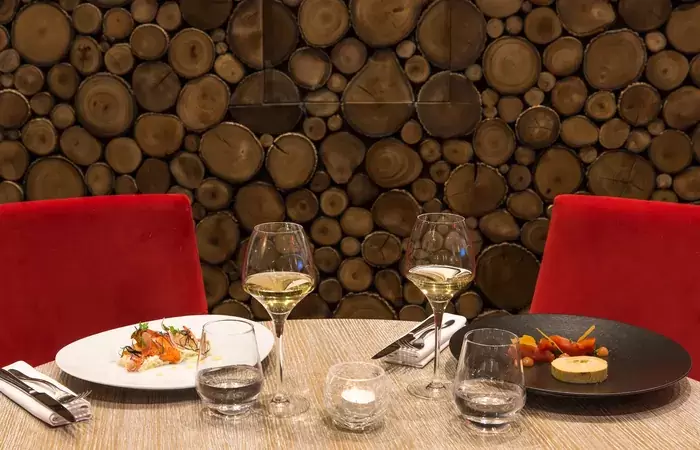 Plated dishes and glasses of white wine in the hotel restaurant, Hotel Mont-Blanc Chamonix