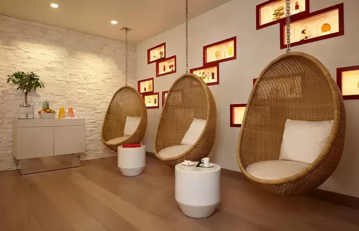 Relaxation room with hanging rattan egg chairs, Spa by Clarins at Hotel Mont-Blanc Chamonix