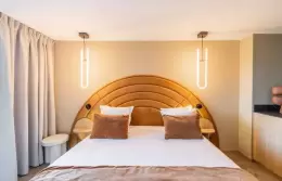 King-size bed with arched headboard in the Junior Suite at Fahrenheit Seven Courchevel