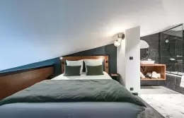 Bedroom with double bed and adjoining bathroom in the Family Duplex Suite, Fahrenheit Seven Courchevel
