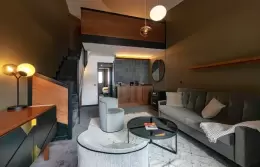 Living room with sofa and staircase in the Family Duplex Suite, Fahrenheit Seven Courchevel