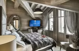 Deluxe Room 2 under a sloping wooden ceiling with an oval mirror, Lys Martagon, Courchevel 1850