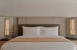 Bed in a bright superior suite at Aman Rosa Alpina.
