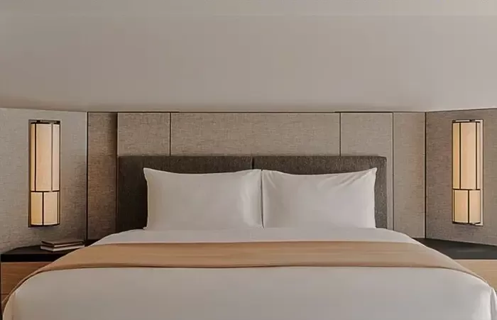 Bed in a bright superior suite at Aman Rosa Alpina.