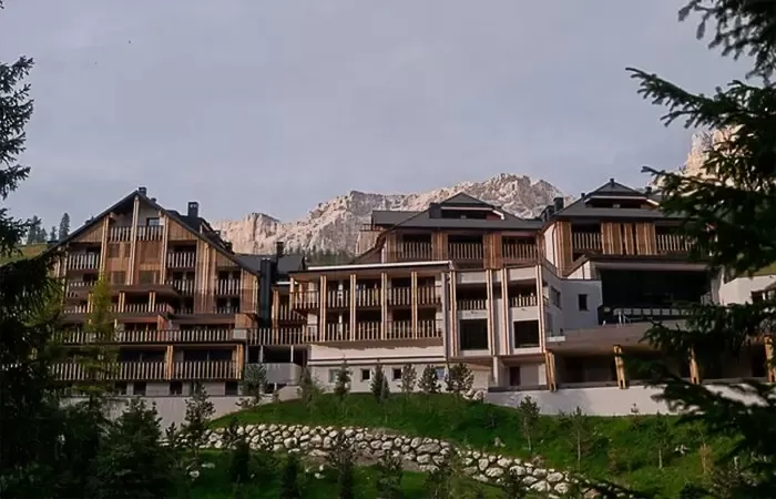 Exterior of Aman Rosa Alpina hotel against mountains.