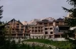 Exterior of Aman Rosa Alpina hotel against mountains.