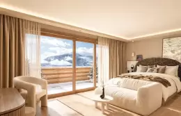 Junior Suite with two armchairs and a small table by the window at Barma, La Tania