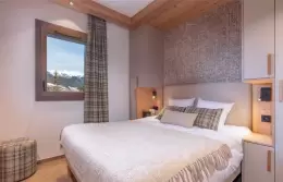 Double bedroom with an upholstered headboard and tartan cushions in a Duo Apartment at Barma Residence, La Tania