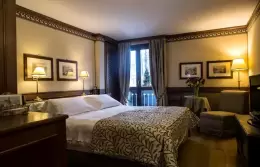 A Classic Room with a double bed and balcony door at Hotel Hermitage, Breuil-Cervinia
