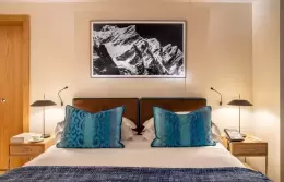 A Junior Suite bed with teal cushions under a mountain print, Hotel Hermitage, Breuil-Cervinia